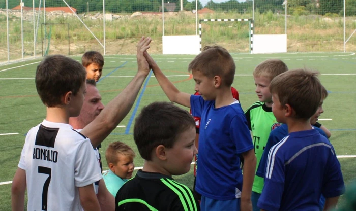 Coach and an athlete give a high-five to each other in the break, when players are having the team talk time.